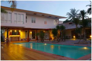 a swimming pool in front of a house at The My Home Resort in Prachuap Khiri Khan