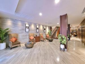a lobby with couches and plants in a building at On 8 Sukhumvit Nana Bangkok in Bangkok