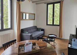 ein Wohnzimmer mit einem Sofa und einem Tisch in der Unterkunft Le nid perché dans la doutre in Angers