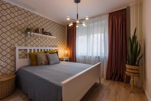 a bedroom with a bed and a plant in a room at Rox Central Apartments 4 in Timişoara