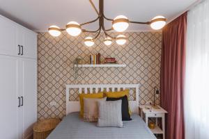 a bedroom with a bed with yellow and white pillows at Rox Central Apartments 4 in Timişoara +21 photos
