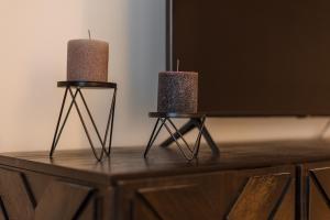 two candles sitting on top of a wooden table at Rox Central Apartments 4 in Timişoara