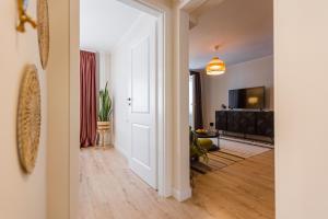a hallway with a white door and a living room at Rox Central Apartments 4 in Timişoara