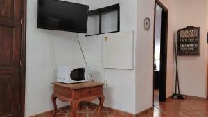 a tv on a wall with a table with a microwave at Aptos Monasterio de San Antonio 2 in Icod de los Vinos