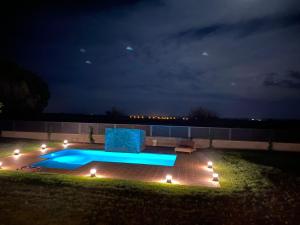 a swimming pool at night with a chair and lights at Villa Sol Peralada Golf in Peralada