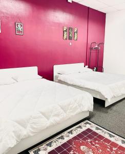 - 2 lits dans une chambre dotée d'un mur violet dans l'établissement AK Greenrise Meru, à Ipoh