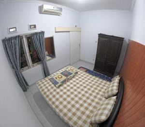a small room with a bed and a window at Omah Wonocatur Homestay Jogja in Demangan