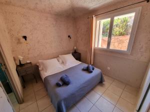 - une chambre avec un lit avec deux oreillers et une fenêtre dans l'établissement CORSACASA Villa in Palombaggia sea view, à Porto-Vecchio