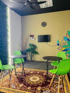 une salle d'attente avec deux tables et des chaises vertes dans l'établissement AK Greenrise Meru, à Ipoh