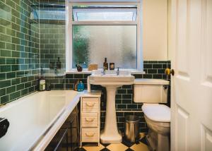 a bathroom with a sink and a tub and a toilet at Stunning 2BR, split-level Flat w garden, Deptford in London