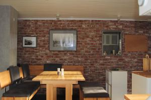 un restaurant avec un mur en briques, une table et des chaises dans l'établissement Haus Rosebud, à Weilheim