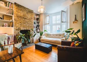 a living room with a couch and a brick wall at Stunning 2BR, split-level Flat w garden, Deptford in London