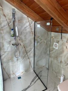 a shower in a bathroom with a marble wall at Casa moderna in Sinteu - intersectia intre modern si linistea naturii in Huta Voivozi