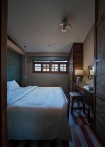 1 dormitorio con cama, escritorio y ventana en Ngâu.House en Thôn Dương Xuân Hạ