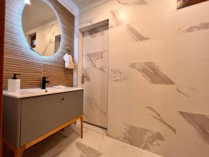 ein Bad mit einem Waschbecken und einem Spiegel in der Unterkunft Amazing Luxury 4 BR Apt 200m2 at Fenerbahçe, Best Location in Istanbul