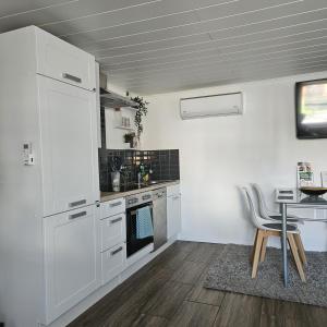 Ferienhaus Rogge-Hof في Lunow: مطبخ به أجهزة بيضاء وطاولة وكراسي