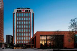 um edifício alto com um relógio em cima em Sheraton Hohhot Hotel em Hohhot