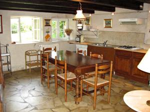 a kitchen with a wooden table and chairs in it at La Basserie in Laguépie