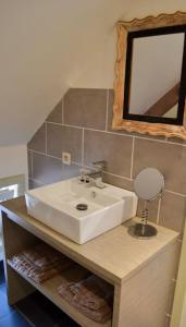 uma casa de banho com um lavatório branco e um espelho. em Vakantiewoning 't Sevencoote - terras - privé parking - Zevekote 