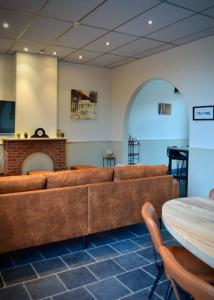 uma sala de estar com um sofá e uma mesa em Vakantiewoning 't Sevencoote - terras - privé parking - Zevekote 