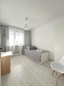 グディニャにある19 Gdynia Centrum - Apartament Mieszkanie dla 8 osの白いリビングルーム(ベッド1台、椅子付)