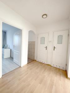 グディニャにある19 Gdynia Centrum - Apartament Mieszkanie dla 8 osの白い壁とウッドフロアの空間