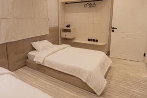 a bedroom with two beds with white sheets and a door at ملاذ 1 in Riyadh
