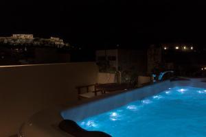 a swimming pool at night on a rooftop at Living Stone Condo Hotel in Athens