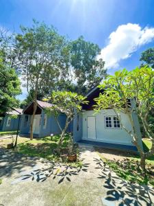 a blue house with trees in front of it at Srikij GardenHome Resort in Sa Kaeo