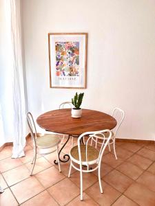 une table et des chaises en bois avec une plante. dans l'établissement A CASA ROSSA , Le Thym, à Saint-Paul-de-Vence
