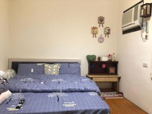 1 dormitorio con cama azul y edredón azul en Jiajia Inn, en Lukang
