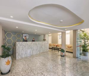 two people standing at a counter in a lobby at Mango Hill Central Ooty in Ooty