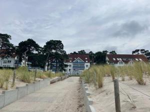 einen Sandstrand mit Häusern und Gebäuden im Hintergrund in der Unterkunft Blaumuschel Sprotte 17 in Lubmin