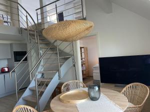 une salle à manger avec une table et un escalier en colimaçon dans l'établissement Blaumuschel Sprotte 17, à Lubmin