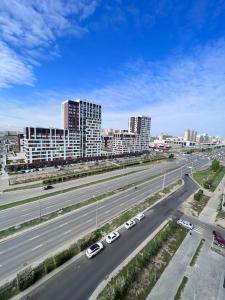 una autopista con coches y edificios en una ciudad en Прекрасное местечко Barys City, en Taldykolʼ