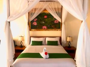 a bedroom with a bed with a stuffed animal on it at Graha Madesimon in Ketewel