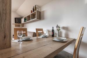 una mesa de madera con copas de vino y platos en ella en Vineyard Cottage Krivic - Happy Rentals, en Trebelno