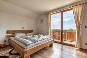 ein Schlafzimmer mit einem Bett und einem großen Fenster in der Unterkunft Vineyard Cottage Krivic - Happy Rentals in Trebelno