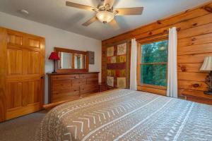 a bedroom with a bed with a ceiling fan and a window at Gorgeous Mountain View Cabin on 12 Acres in Candler