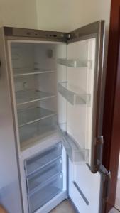 an empty refrigerator with its door open in a room at Ferienwohnung DaWi Röhrenfurth in Melsungen