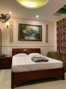 een slaapkamer met een bed en een schilderij aan de muur bij Jerry Hotel - Số 9 Ngõ 604 Trường Chinh - by Bay Hostel in Hanoi