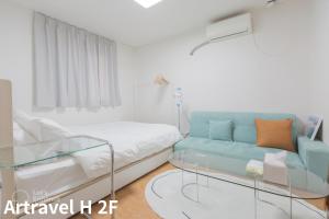 Cette petite chambre comprend un lit et un canapé. dans l'établissement Artravel Hongdae, à Séoul