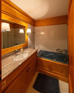 a bathroom with a sink and a bath tub at CHALET du GOLF CRANS MONTANA in Crans-Montana