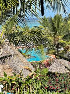 een uitzicht op een strand met palmbomen en bloemen bij Hotel Club Dongwe in Pingwe