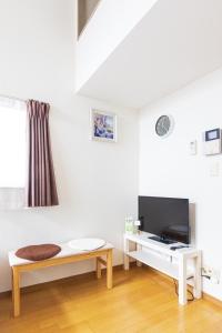 a white living room with a bench and a tv at 博多駅東貸切Hakataekihigashi Apartment LOFT付き 敷地内駐車場 地下鉄5分国際線博多駅 in Fukuoka