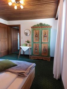 a bedroom with a green cabinet and a table at Vorderweinaugut in Annaberg im Lammertal