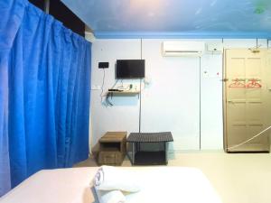 a bedroom with a bed and a blue curtain at Pen'U Cottages by RVH in Dungun