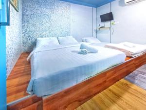 a large white bed in a room with wooden floors at Pen'U Cottages by RVH in Dungun