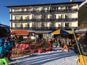 un grupo de personas de pie en la nieve frente a un edificio en Apartment with great view at Residence Brunner en Wengen
