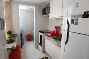een kleine keuken met een koelkast en een wastafel bij Duplex com 02 suítes, mobiliado e reformado em Vilas do Atlântico in Lauro de Freitas